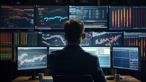 A professional working in a modern office surrounded by screens of financial data.