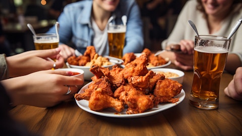 Customers savoring boneless wings at a bustling restaurant owned by the company.