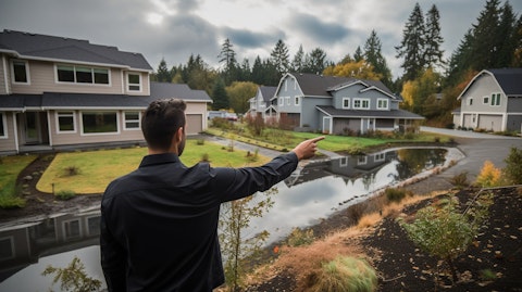 An employee of the company pointing out the features of a house to a first-time homebuyer.