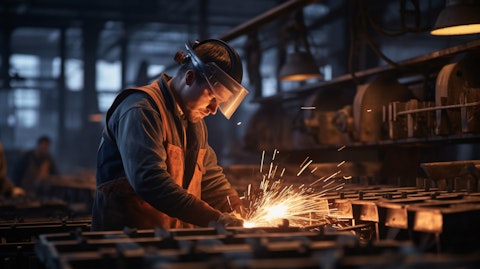 A factory worker operating a machine that processes steel products.