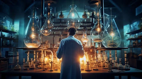 A laboratory full of vials, tubes and Bunsen burners, with a scientist in the center examining a chemical.