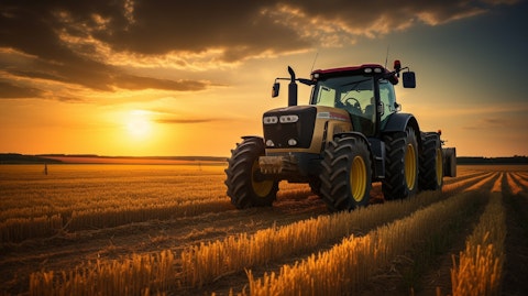 A tractor plowing a field in the warm golden light of a setting sun.