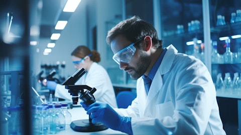 A team of scientists wearing lab coats and protective eyewear in a research laboratory, intently looking into microscopes and analyzing results.