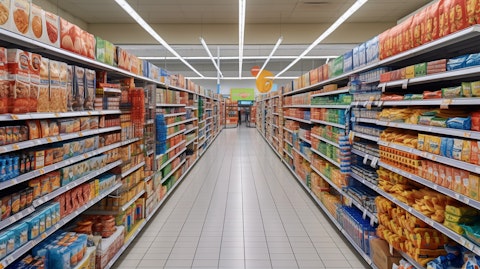 A variety of grocery items in their respective aisles of a superstore representing the company brand.