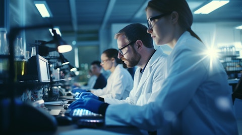 A biopharmaceutical research team taking notes in front of a laboratory's microscope.