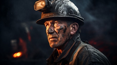 A coal miner working in a surface mine, wearing a hard hat and carrying a pick.
