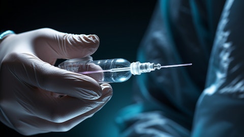 A close up of a hand, fingers wrapped around a fertility specialist syringe.