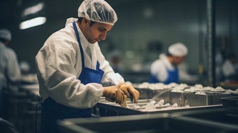 A worker assembling a meal in a food production facility.