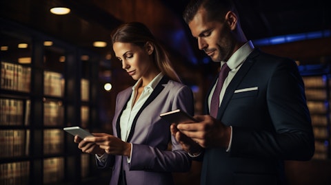 A man and a woman in matching suits with a a digital tablet highlighting a payment solution.