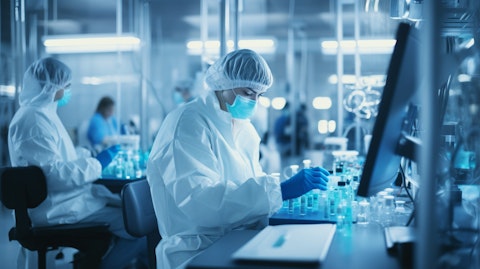 A laboratory with workers in masks and lab coats focused on analyzing cell therapies.