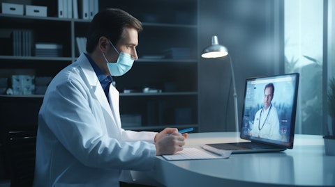 A doctor wearing a face mask and lab coat providing remote medical advice via video chat.