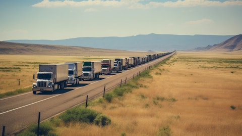 A long line of trucks transporting goods across the open road, symbolizing the long-distance transportation services of the company.
