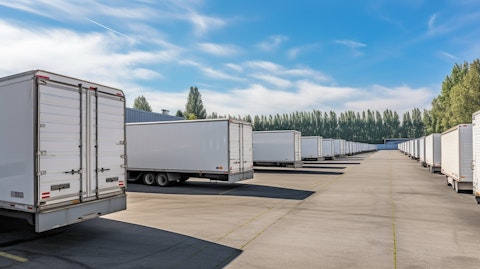 A line of rental trucks, trailers and portable units parked at a self-storage facility.