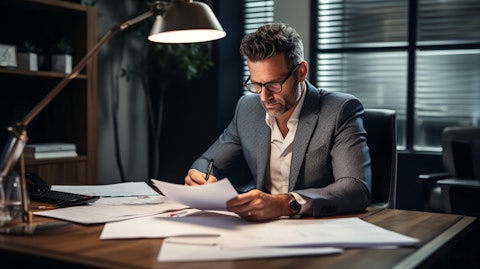 An investor sitting at a desk looking through financial documents, representing the private client group.