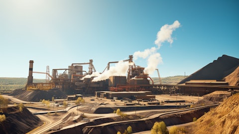 A large coal mining complex on a sunny day, with heavy machinery moving vast amounts of earth.