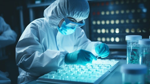 A microbiologist in protective gear studying samples in a laboratory.