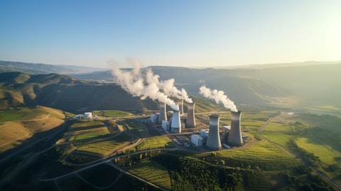 An aerial view of a power plant surrounded by majestic rolling hills.