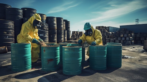 A team of waste management experts inspecting a stack of hazardous waste barrels.