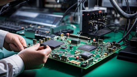 A technician using a specialized tool to mount a wireless analog system on chip.