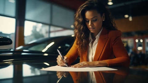 A woman signing documents related to a loan secured by an automobile.