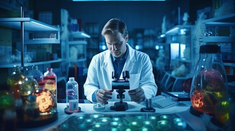 A doctor holding a microscope in front of a laboratory sample of healthcare products.