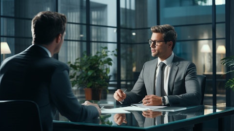 An experienced financial consultant in a suit providing advice to a client in a large office.