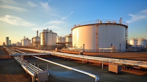 A large oil and gas production plant with pipelines leading to tanker truck and storage tanks.