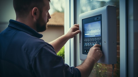 A security specialist installing a home security panel, showing the safety and security the company provides.