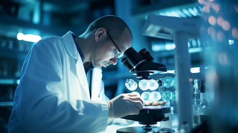 A medical researcher in a lab coat working on a microscope against a background of cancer cells.