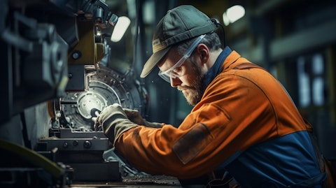 A machinist worker in a factory using a precision cutting tool.