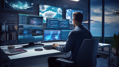 An experienced software developer architecting a cloud software solution on multiple monitors.