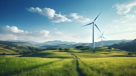 A wind turbine in a large green field, highlighting the companies commitment to renewable energy.