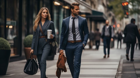 A man and woman in business attire walking down a street, bags of clothing in hand.