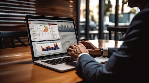A businessperson on a laptop analyzing a chart of credit card loan data.