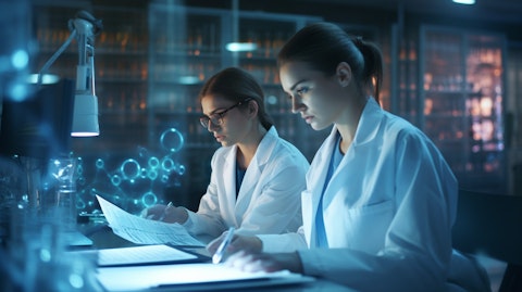 A pathologist and a laboratory assistant in a laboratory researching medical news and data.