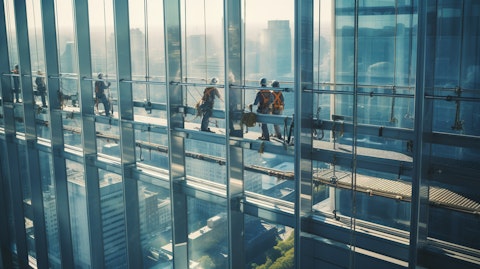 Elevated view of workers in protective gear installing an array of aluminum frame windows onto a busy building.
