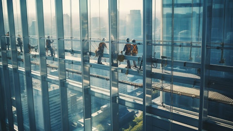 Elevated view of workers in protective gear installing an array of aluminum frame windows onto a busy building.