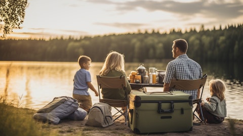 A family enjoying a camping trip, with the company's coolers, cargo bags, and other outdoor lifestyle products in the frame.