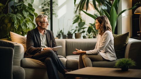 A financial advisor sitting with a customer in a living room discussing their financial future.