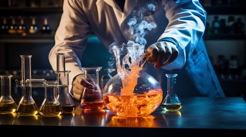 A laboratory technician pouring a specialty blend of industrial chemicals into a beaker.