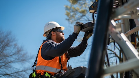 A technician installing advanced cellular equipment at a 5G cell tower.