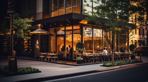 The golden glow of the exterior of a modern Upscale Casual Dining restaurant reflecting on a busy street.
