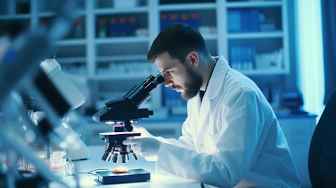 A scientist using a microscope to inspect a tissue sample in a research lab setting.