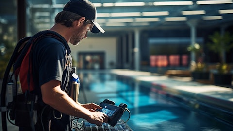 A technician in safety gear inspecting a pool automated system.