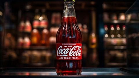 A close-up of a bottle of Coca-Cola, showing its iconic branding, from the factory shelves.