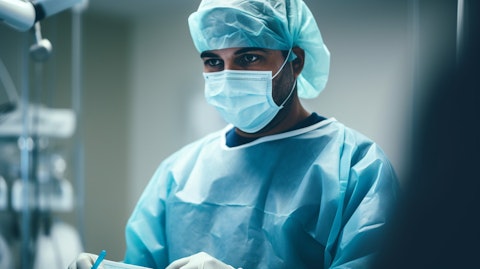 A surgeon wearing gloves and a mask, performing a procedure in a well-equipped surgical facility.