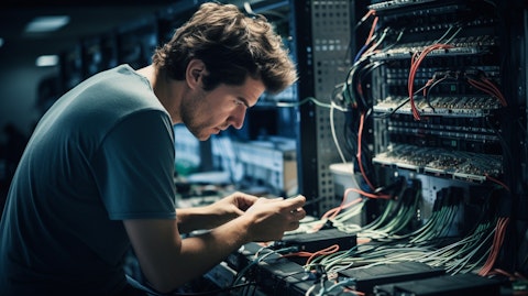 A technician in a telecom facility installing wireless routers and operating on a computer.