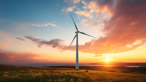 A wind turbine silhouetted against an idyllic sunset, representing clean energy projects.