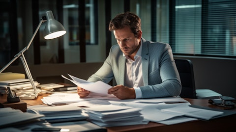 A professional working alone at a desk, going through corporate action services paperwork.