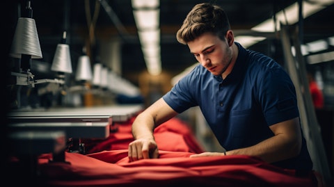 A factory worker using modern technology to assemble a garment.